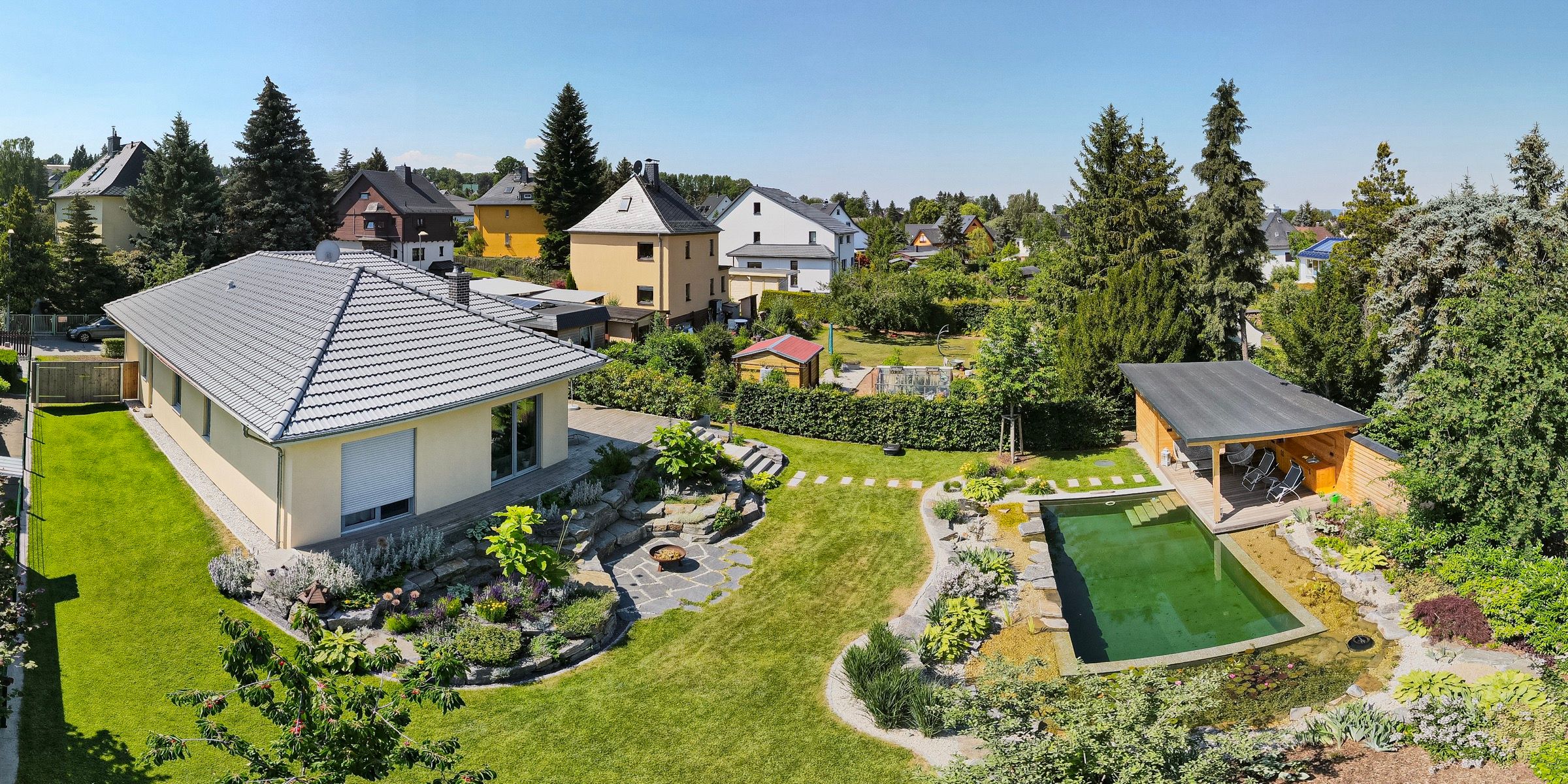 Drohnenaufnahme des Gartens mit Naturpool und Gartenhaus